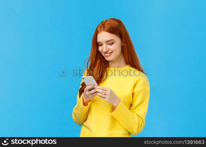 Conversation, messaging and people concept. Redhead cute carefree girl enjoy browsing online, picking new dress internet store, shopping using smartphone, smiling found excellent choice, order.. Conversation, messaging and people concept. Redhead cute carefree girl enjoy browsing online, picking new dress internet store, shopping using smartphone, smiling found excellent choice, order