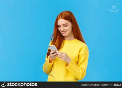 Conversation, messaging and people concept. Redhead cute carefree girl enjoy browsing online, picking new dress internet store, shopping using smartphone, smiling found excellent choice, order.. Conversation, messaging and people concept. Redhead cute carefree girl enjoy browsing online, picking new dress internet store, shopping using smartphone, smiling found excellent choice, order