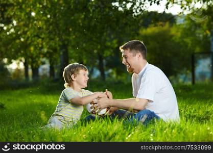 Conversation of father and small son in a summer garden