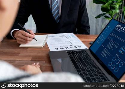 Conversational job interview between interviewer and candidate. Asian female job applicant present her performance and qualification by digital resume on laptop and CV paper to HR manager. Jubilant. Conversational job interview between interviewer and candidate. Jubilant