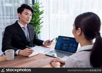 Conversational job interview between interviewer and candidate. Asian female job applicant present her performance and qualification by digital resume on laptop and CV paper to HR manager. Jubilant. Conversational job interview between interviewer and candidate. Jubilant