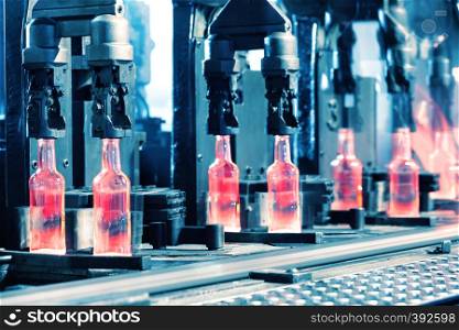Conveyor production of glass bottles toned in blue. Conveyor production of glass bottles