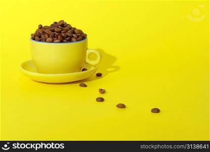 cooffee beans and cup on yellow background