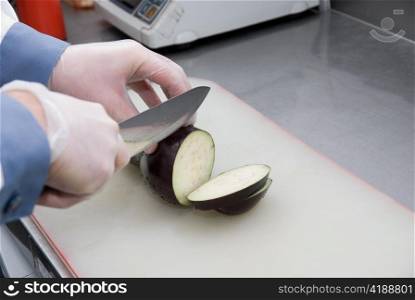 Cook cutting a zucchini at kitchen board