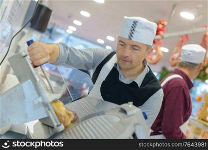cook in apron cuts appetizing ham