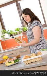Cook - plus size woman prepare fish with white wine and bread in modern kitchen