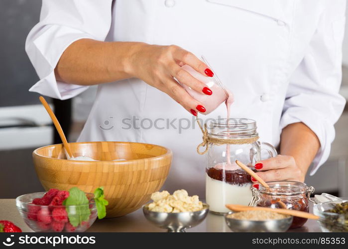 Cook preparing a dessert based on yogurt and cereals