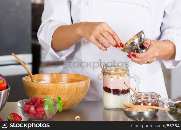 Cook preparing a dessert based on yogurt and cereals