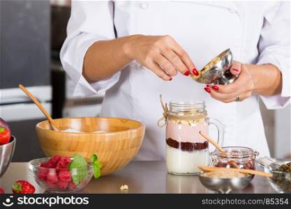 Cook preparing a dessert based on yogurt and cereals