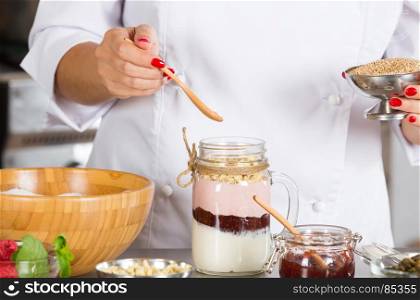 Cook preparing a dessert based on yogurt and cereals