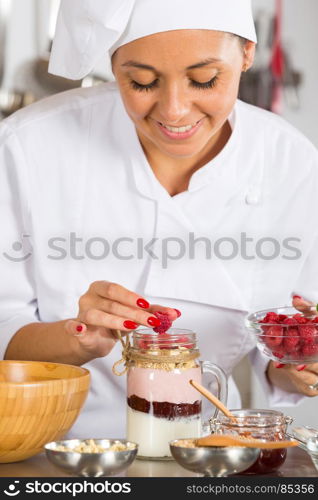 Cook preparing a dessert based on yogurt and cereals