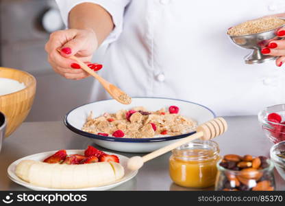 Cook preparing a dessert made with yogurt fruits and cereals