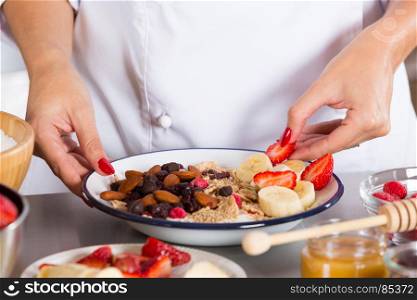 Cook preparing a dessert made with yogurt fruits and cereals