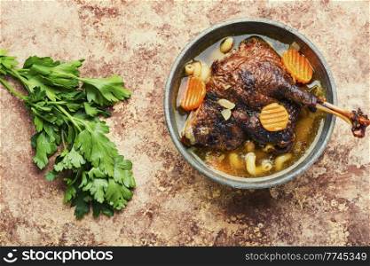 Cooked aromatic goose leg soup with pasta. Delicious soup with a goose leg