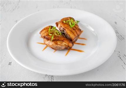 Cooked duck breast on the plate, white background