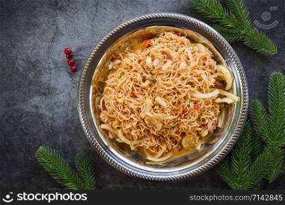 Cooked instant noodles on plate / Noodle spicy salad with fir branches decoration festive food lunch festive christmas dinner