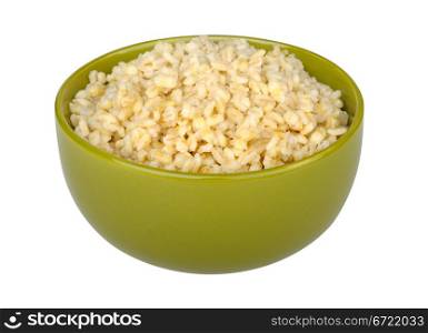 cooked pearl barley in a green bowl isolated on white background