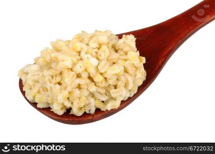 cooked pearl barley in a wooden spoon isolated on white background