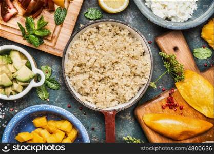 Cooked quinoa in pot with Healthy cooking ingredients, top view, close up