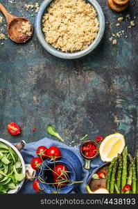 Cooked quinoa with wooden spoon and cooking ingredients on dark rustic background, top view, place for text, vertical