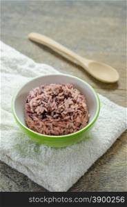 Cooked rice of Riceberry. Cooked rice of Riceberry in green bowl on wooden table