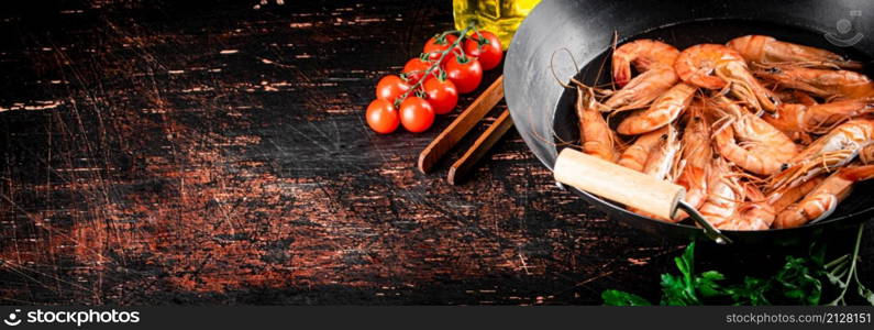 Cooked shrimp in a saucepan with parsley and tomatoes. On rustic dark background. High quality photo. Cooked shrimp in a saucepan with parsley and tomatoes.