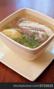 cooked soup with lamb meat, potatoes and vegetables