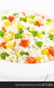 Cooked white rice mixed with colorful vegetables (onion, carrot, green peas, corn, green beans) in white bowl (Selective Focus, Focus one third into the dish). Rice with Vegetables