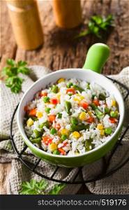Cooked white rice mixed with colorful vegetables (onion, carrot, green peas, corn, green beans) in bowl (Selective Focus, Focus one third into the dish). Rice with Vegetables
