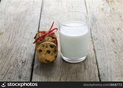cookies and a glass with milk on wooden table