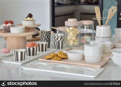 Cookies and cupcakes with cute bakeware setting on white top table
