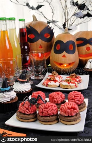 Cookies brains of marzipan on a table with a variety of sweets in honor of Halloween