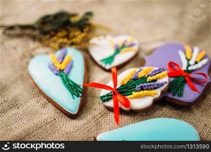 Cookies in the glaze with pictures on burlap background closeup view