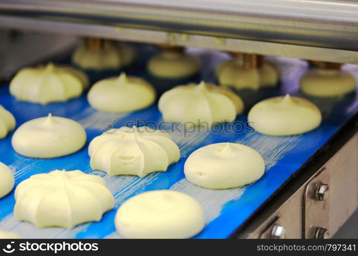 Cookies manufacturing process. Automated cookie depositor machine in action.