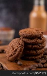 Cookies with coffee beans placed on a wooden plate.