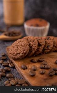 Cookies with coffee beans placed on a wooden plate.