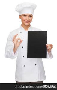 cooking, advertisement and food concept - smiling female chef, cook or baker with blank black paper showing ok sing