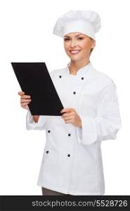 cooking, advertisement and food concept - smiling female chef, cook or baker with blank black menu paper