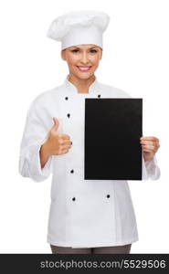 cooking, advertisement and food concept - smiling female chef, cook or baker with blank black paper showing thumbs up