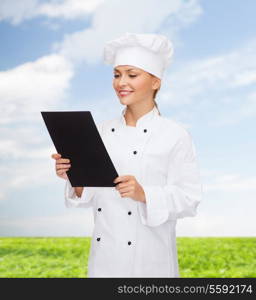 cooking, advertisement and food concept - smiling female chef, cook or baker with blank black menu paper