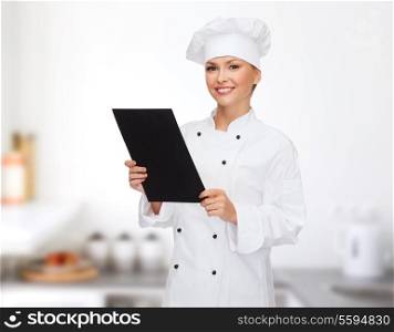 cooking, advertisement and food concept - smiling female chef, cook or baker with blank black menu paper