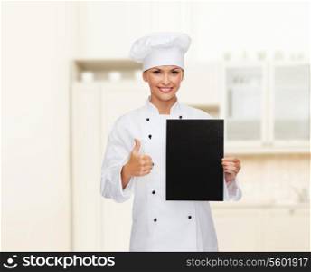 cooking, advertisement and food concept - smiling female chef, cook or baker with blank black paper showing thumbs up