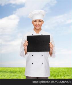 cooking, advertisement and food concept - smiling female chef, cook or baker with blank black paper
