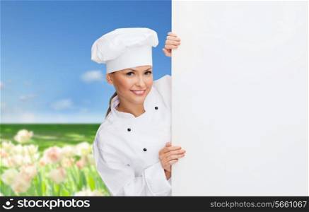 cooking, advertisement and food concept - smiling female chef, cook or baker with white blank board
