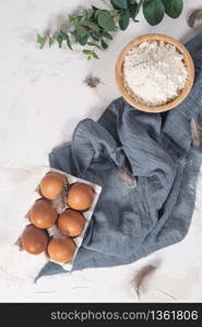 Cooking and baking concept. Baking ingredients on white background. Eggs and flour. Home baking, homemade cooking flat lay top view