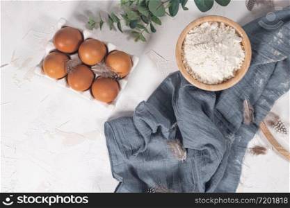 Cooking and baking concept. Baking ingredients on white background. Eggs and flour. Home baking, homemade cooking flat lay top view