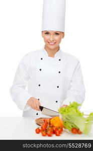 cooking and food concept - smiling female chef chopping vegetables