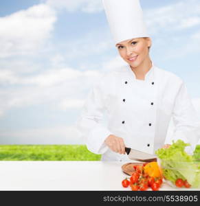 cooking and food concept - smiling female chef chopping vegetables