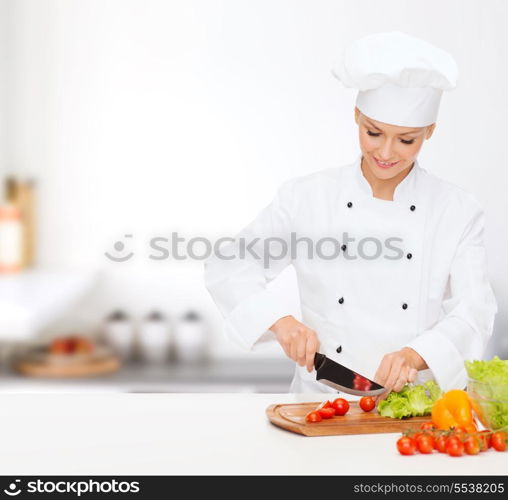 cooking and food concept - smiling female chef, cook or baker chopping vegetables