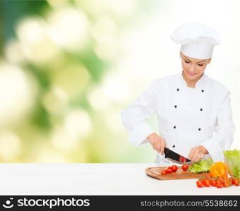 cooking and food concept - smiling female chef, cook or baker chopping vegetables